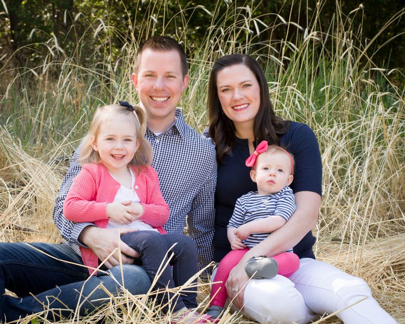 Dr. Scott Robinson with wife and children outdoors in grass